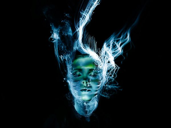 Silhouette of a person in a fluid dance-like motion against a colored background.
